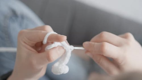 Woman Crocheting White Yarn with Green Crochet Hook