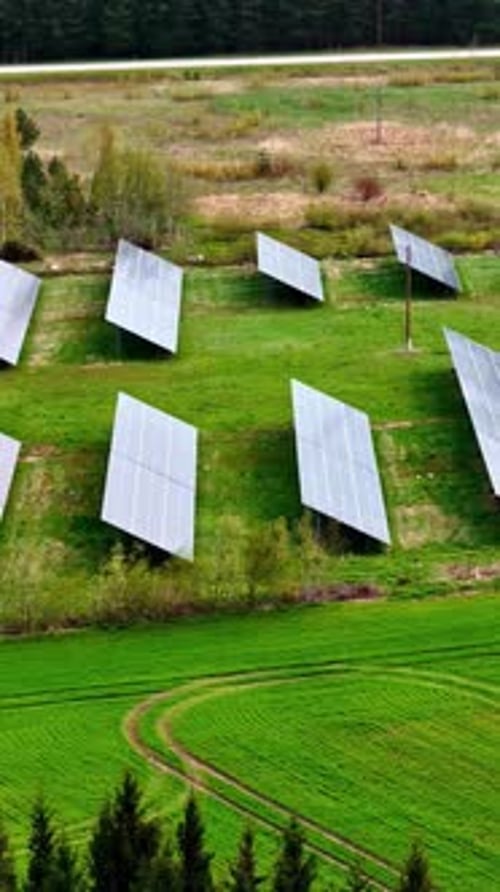 Solar panels in green fields, aerial drone vertical view
