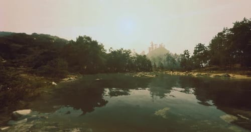 Serene Lake Surrounded By Trees and Mountains in Early Morning Light