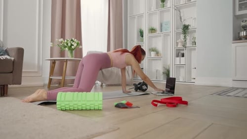 Tutoriales de acondicionamiento físico en línea para amas de casa, mujeres que entrenan en casa, analizan el portátil, un estilo de vida saludable y