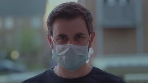 Adult Wearing a Surgical Mask Looking at Camera