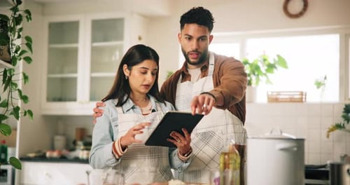 Couple Cooking Together Using Tablet Recipe in Kitchen