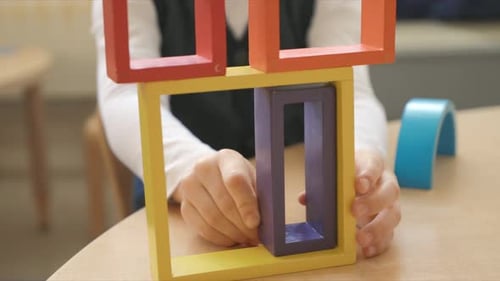 Junge im Vorschulalter spielt im Klassenzimmer mit Bausteinen 45 Jahre