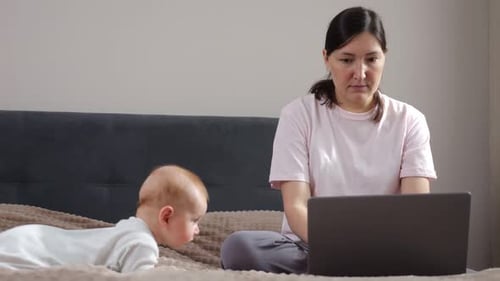 Freelance Mom Manages Job And Parenting Caregiver And Professional Multitasking In Cozy Bedroom
