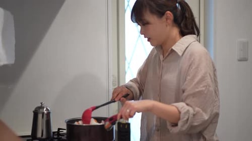 Woman Cooking Vegetables in a Kitchen Pot
