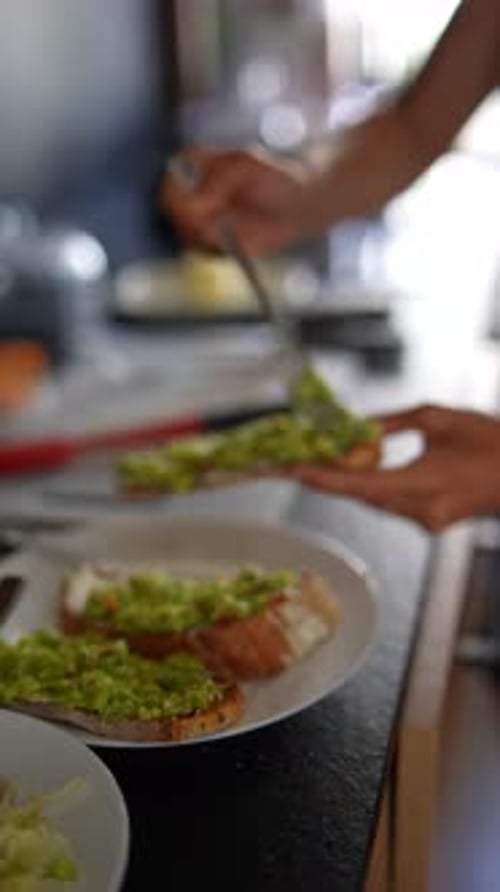 Person Spreading Avocado on Toast for a Meal