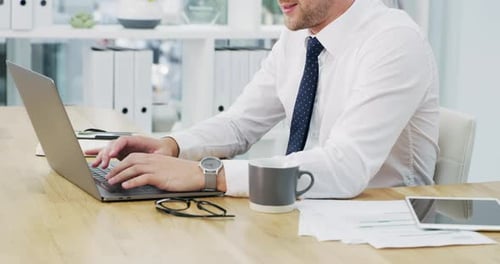 4k video footage of an unrecognisable businessman working on a laptop in an office