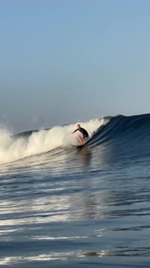 Young Man Surfs in the Ocean