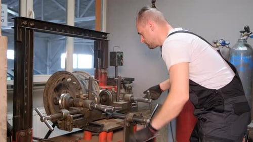 Restoration of a Damaged Wheel Disc in the Garage Car Tire Repair Mechanic Checking Car Wheel Rim