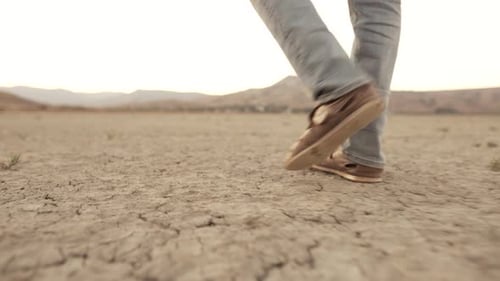 Feet of a Man Walking Through the Desert