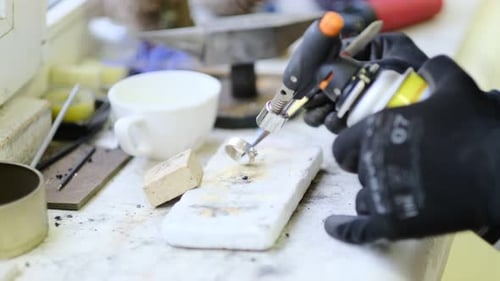 Jeweler Soldering Ring with Torch on Workbench