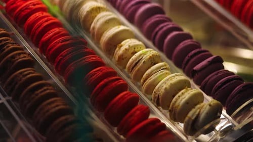 Slowmo-Pfanne links, hintere Ecke der Glasvitrine mit dekadenten Pariser Macarons