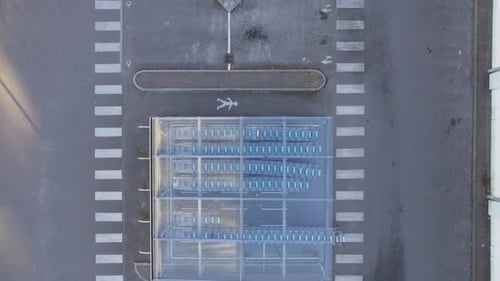 Shopping Cart Storage With Clear Glass Roof Next To Empty Carpark Of A Supermarket. aerial drone top