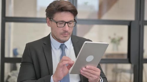 Professional Adult Man Using Tablet in Office