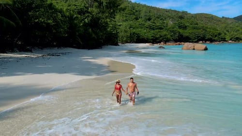 Couple Walking on the Beach of Anse Lazio Beach Praslin Island Seychelles