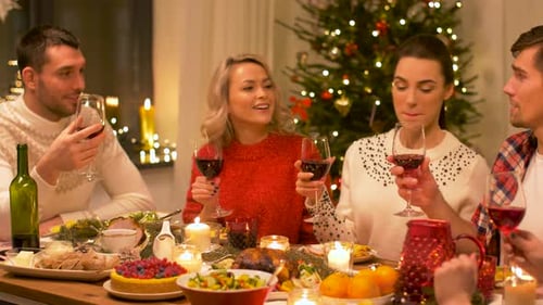 Friends celebrate the holidays around festive dinner table