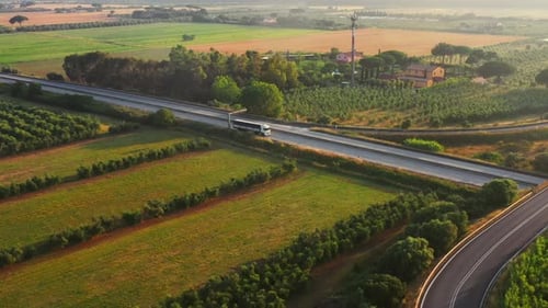 Aerial Drone Footage: Long Haul Semi Trucks Driving on the Busy Highway in the Rural Region of Ital