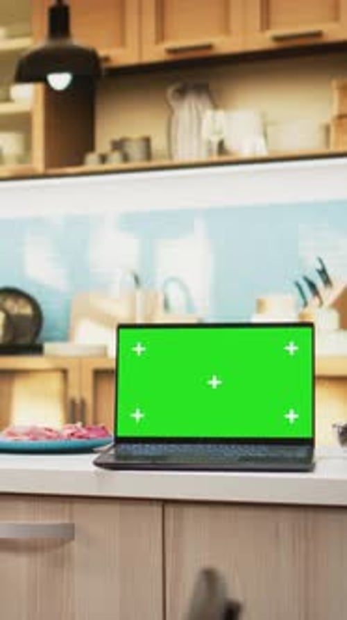 Vertical Video Green Screen on Laptop in Modern Home Kitchen with Cupboards and Cookware