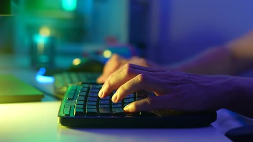 Nahaufnahme Unerkennbarer männlicher Spieler, die beim Spielen eines Online-Videospiels die Tastaturtasten drücken