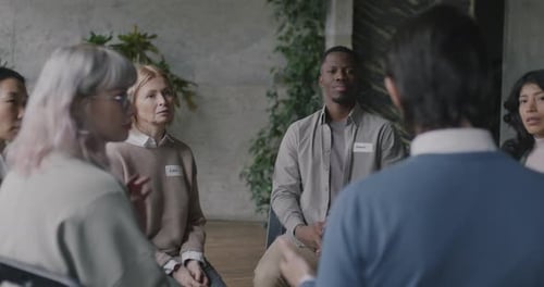 Diverse Group of People Sitting at Meeting Sharing Problems Concentrated on Therapy in Rehab Center