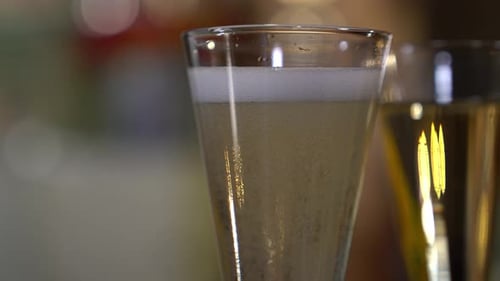 A shot of sparkling wine as the the bubbles rise to the top of the glass and settle down again.