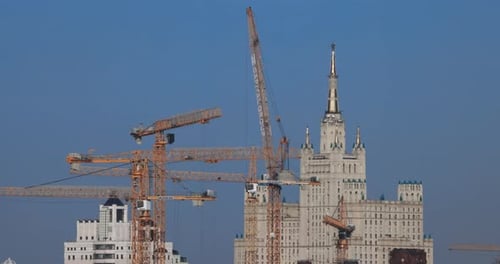 Construction Cranes Towering Over City Buildings