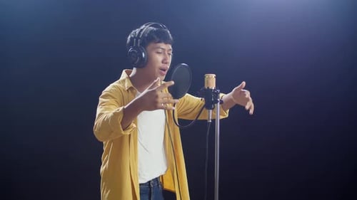 Young Adult Singing into Microphone in Studio