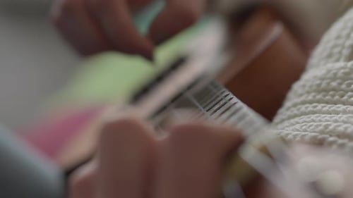 Close Up of Musician Playing Ukulele Indoors