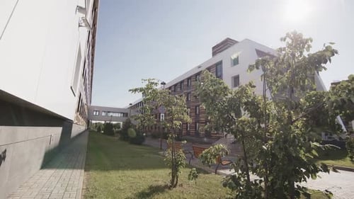 Small Green Park Near Buildings with Tunnel Bridge in Town