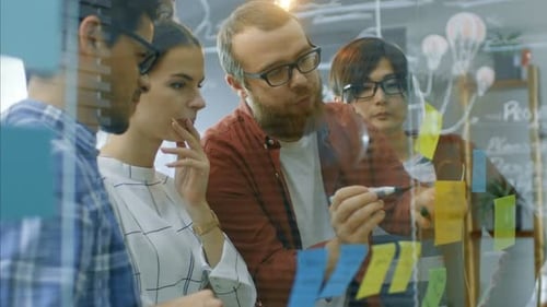 Diverse Team Collaborates on Sticky Note Project in Office