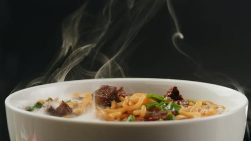 Steaming Bowl of Noodles with Meat and Vegetables