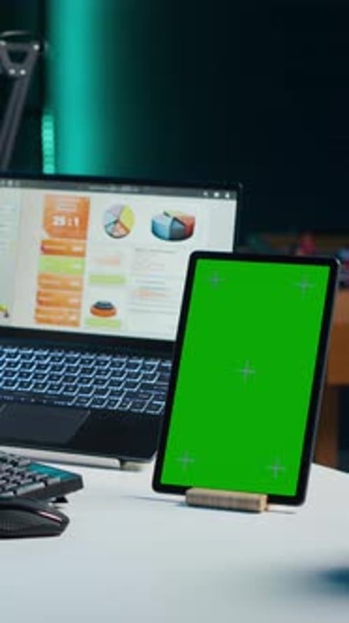 Vertical Video Freelancer Using Isolated Screen Tablet Analyzing Statistical Charts on Laptop