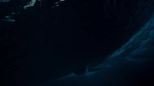 Dark underwater ocean gradient surfer turning off wave top slow motion