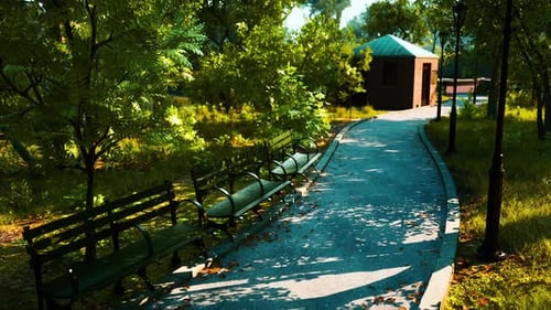 A Peaceful Park Path with Benches and a Small Building in the Afternoon Light
