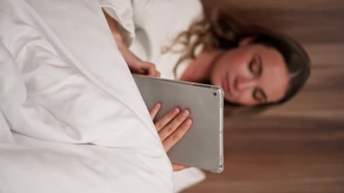 Vertical Video Close Up in Modern Clinic in a Bright VIP Room a Young Girl in a White Coat Lies on a