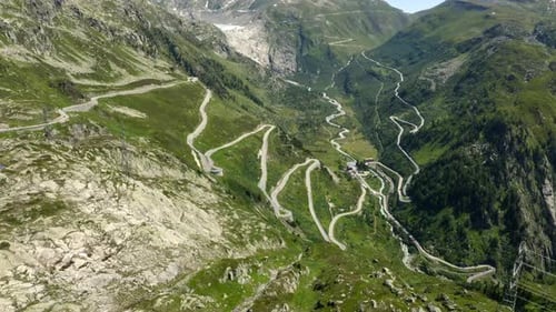 Slow orbit over Grimsel pass road in the Swiss alps, with view of the valley and river below and the