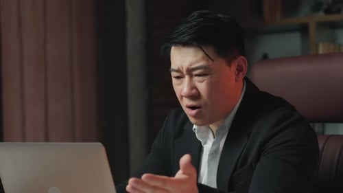 Man in Suit Having Tense Online Meeting