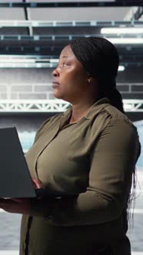 Vertical Video Technician in Server Farm Using Laptop to Upgrade Rigs