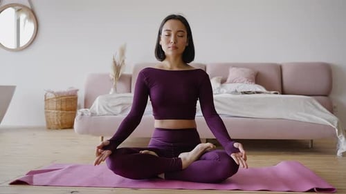 Woman Meditates in Yoga Pose at Home