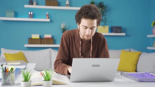 Young Adult Works on Laptop at Home Office