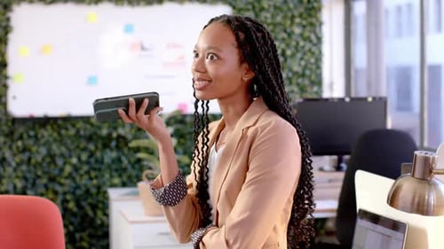 Happy african american casual businesswoman talking on smartphone in office, slow motion