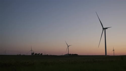 Wide Drone View of a Silhouette Wind Farm Park with Wind Turbines Standing in a Wheat Field at