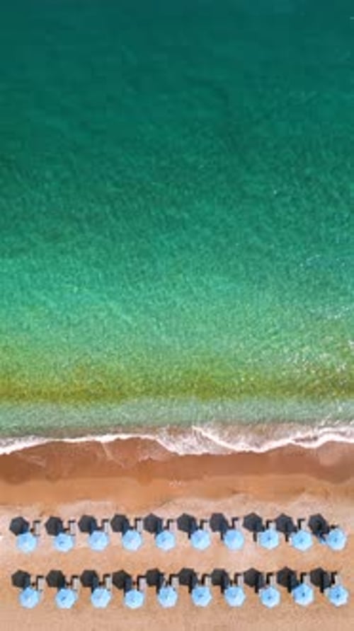 Topdown View of Sandy Beach with Sun Umbrellas and Turquoise Sea Water