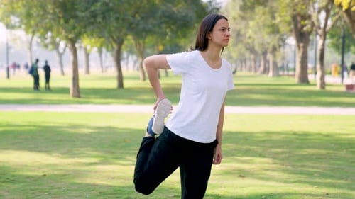 Woman Stretching Quadriceps in Park