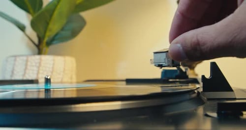 Hand Places Needle on Vinyl Record Player