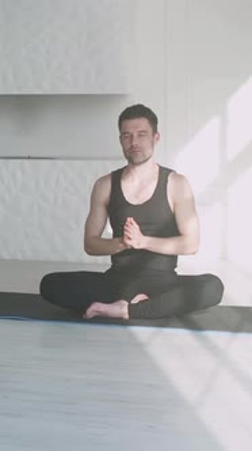 Man Practices Yoga in a Bright, Airy Room