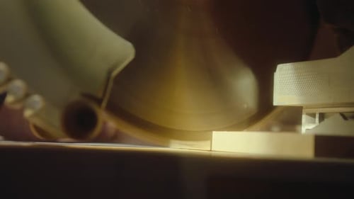 Person cutting wood with a chop saw