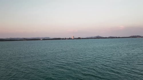 Drone Flying Toward Distant Coastal City