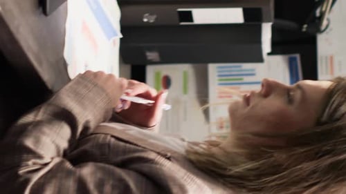 Young Woman Works with Charts and a Laptop