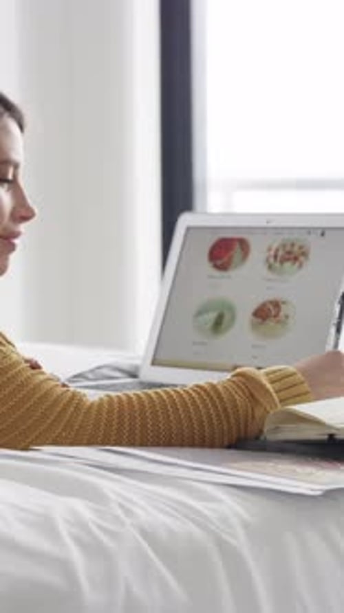 Woman, student and writing with laptop for hospitality course or online research in bedroom